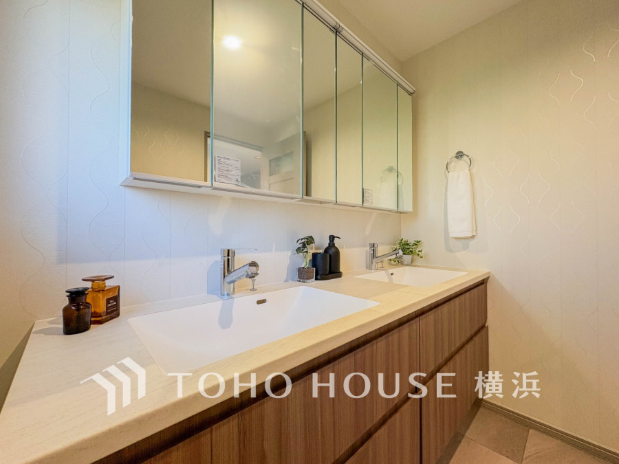 木目調の収納が美しい、清潔感あふれるダブルシンクの洗面スペース。毎日の身支度を快適にサポートします。