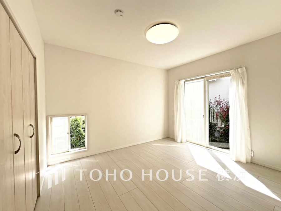 大きな窓から自然光が差し込むシンプルで清潔感のある洋室。収納も充実しています。