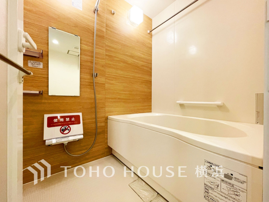 木目調の壁が温かみを演出する、清潔感あふれるバスルームです。ゆったりとくつろげる浴槽付き。