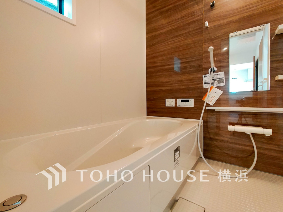 木目調の壁が温かみを演出する清潔感あふれるバスルーム。