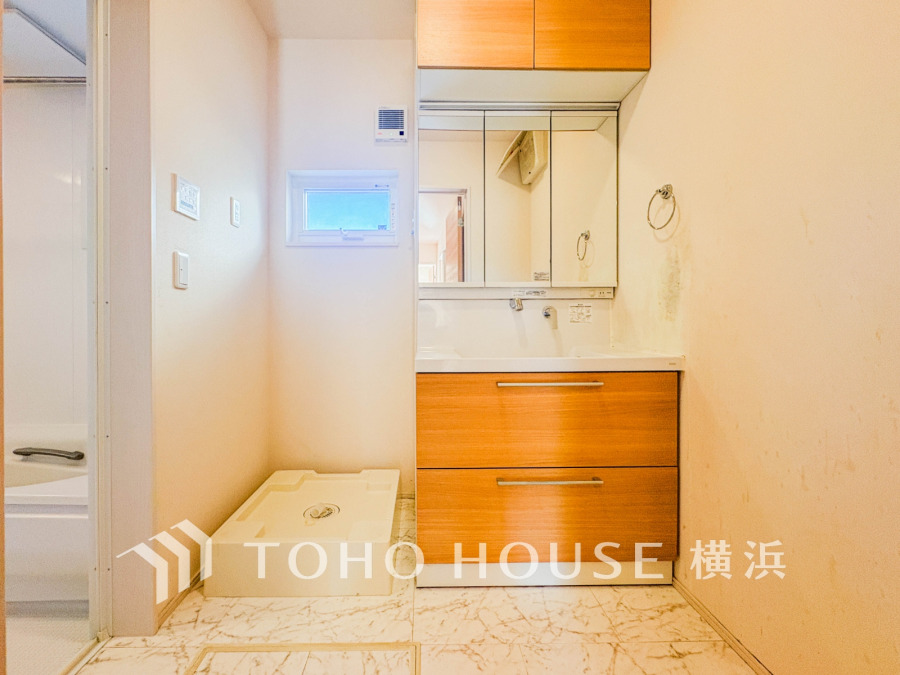 ナチュラルな木目調の洗面台と小窓が明るさを演出する清潔感ある洗面スペースです。