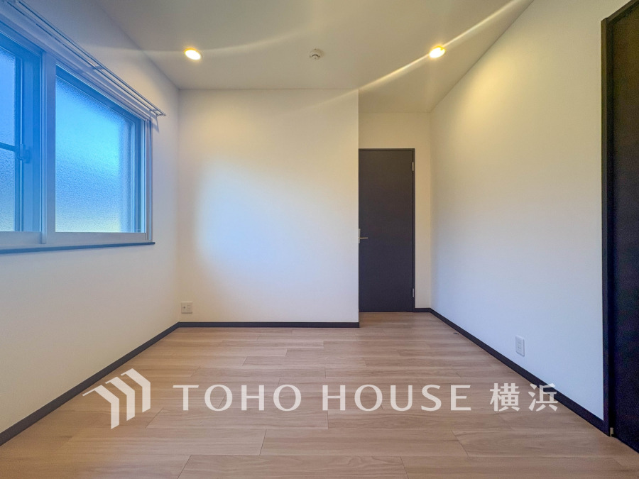 明るい自然光が差し込むシンプルで清潔感のある洋室。落ち着いた色調で多目的に使えます。