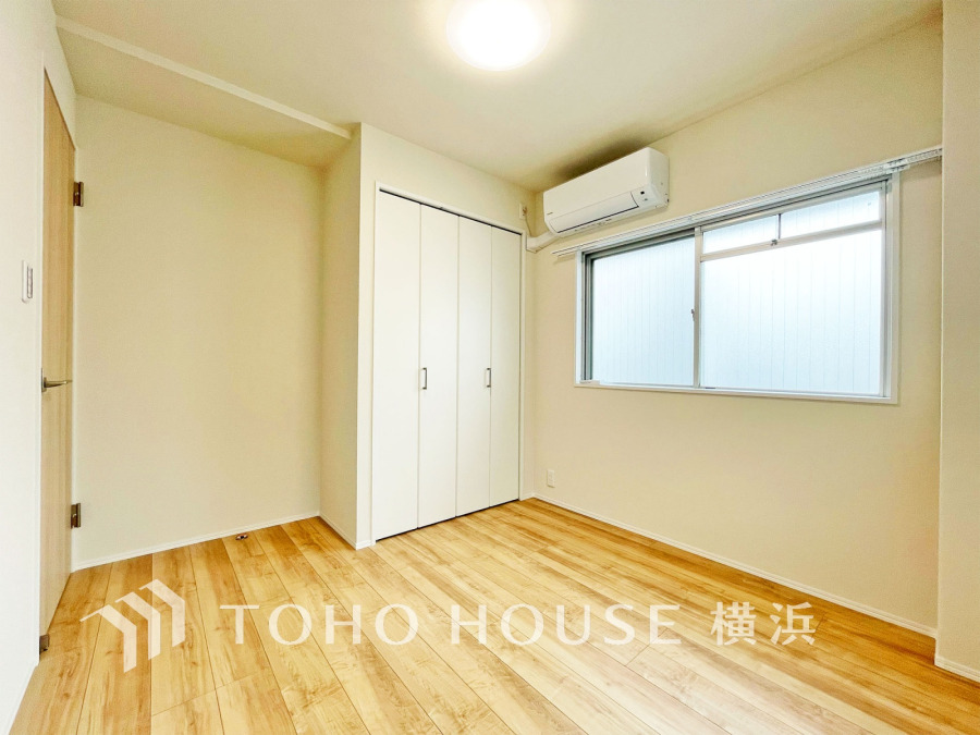 窓から光が差し込む、明るく清潔感あふれる洋室。収納スペースも充実しています。