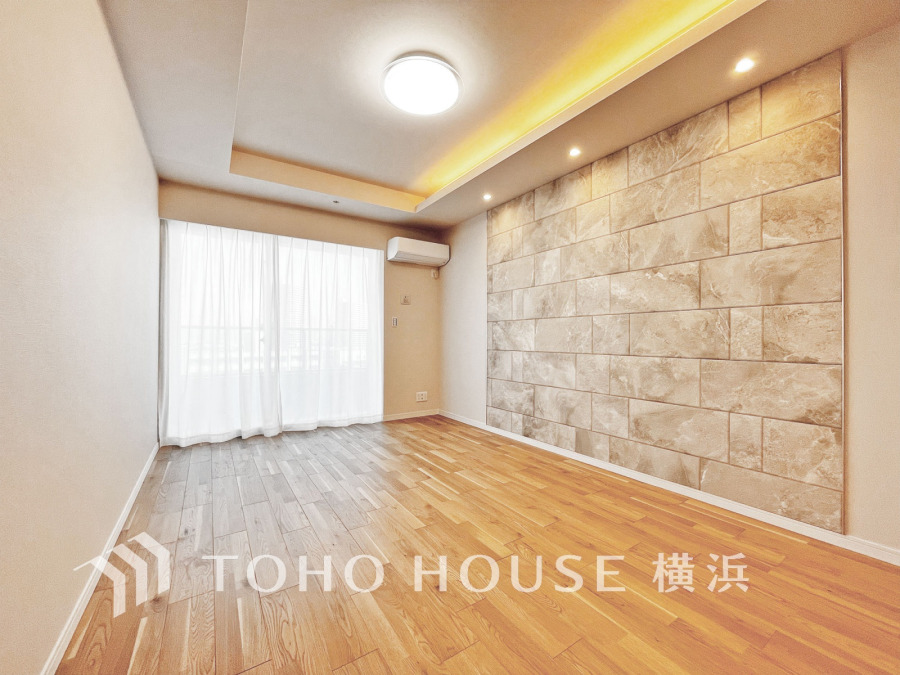 自然光が差し込む明るいリビング。アクセントウォールと間接照明が上質な空間を演出します。