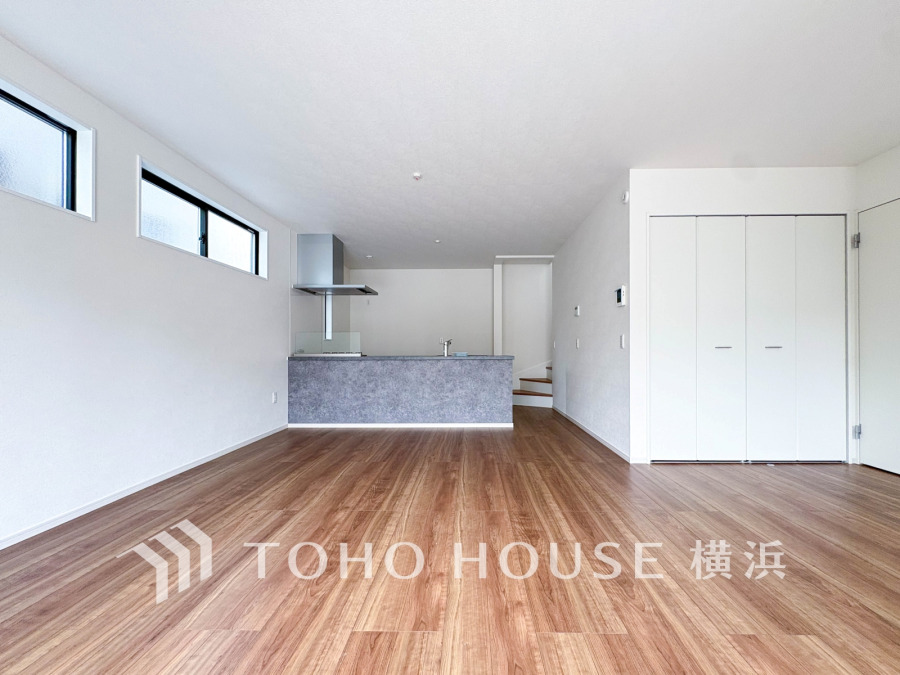 ナチュラルな木目床と白壁が調和する、明るく開放的なリビング・キッチン空間です。収納も充実しています。