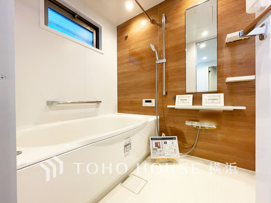 木目調パネルが温かみを演出する清潔感あふれる浴室。窓からの自然光で明るく快適な空間です。