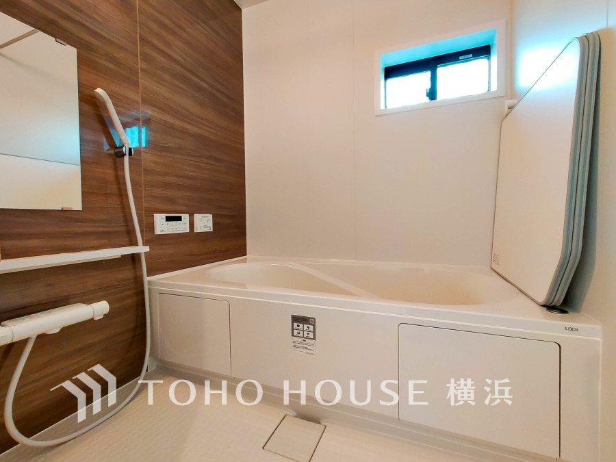 木目調のアクセント壁が温かみを添える清潔感あふれるバスルーム。小窓で自然光もたっぷり取り込めます。