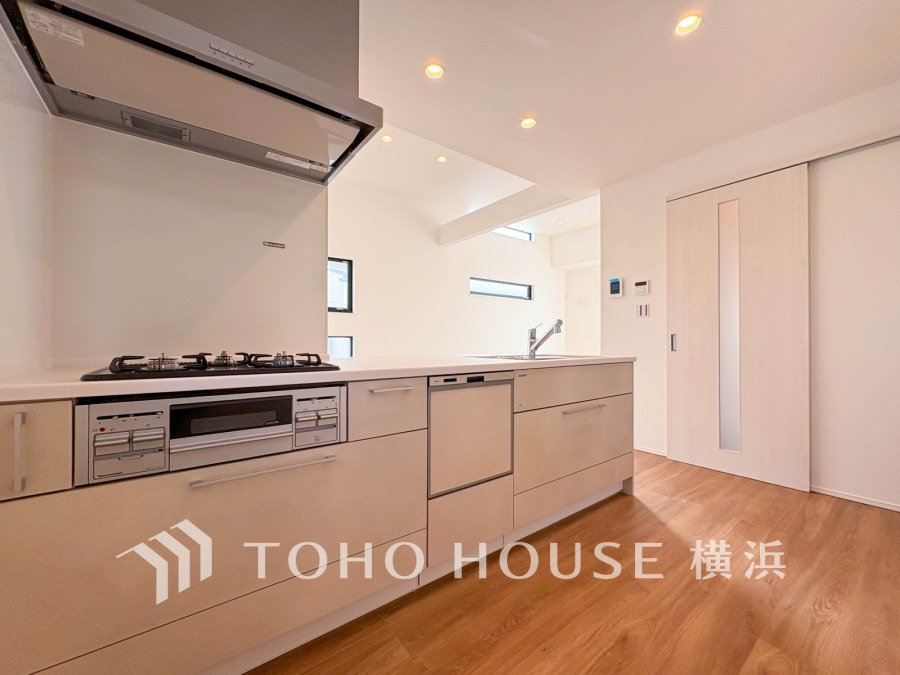 清潔感あふれる白を基調としたシステムキッチン。使いやすく機能的な収納と設備が揃い、家事効率を高めます。