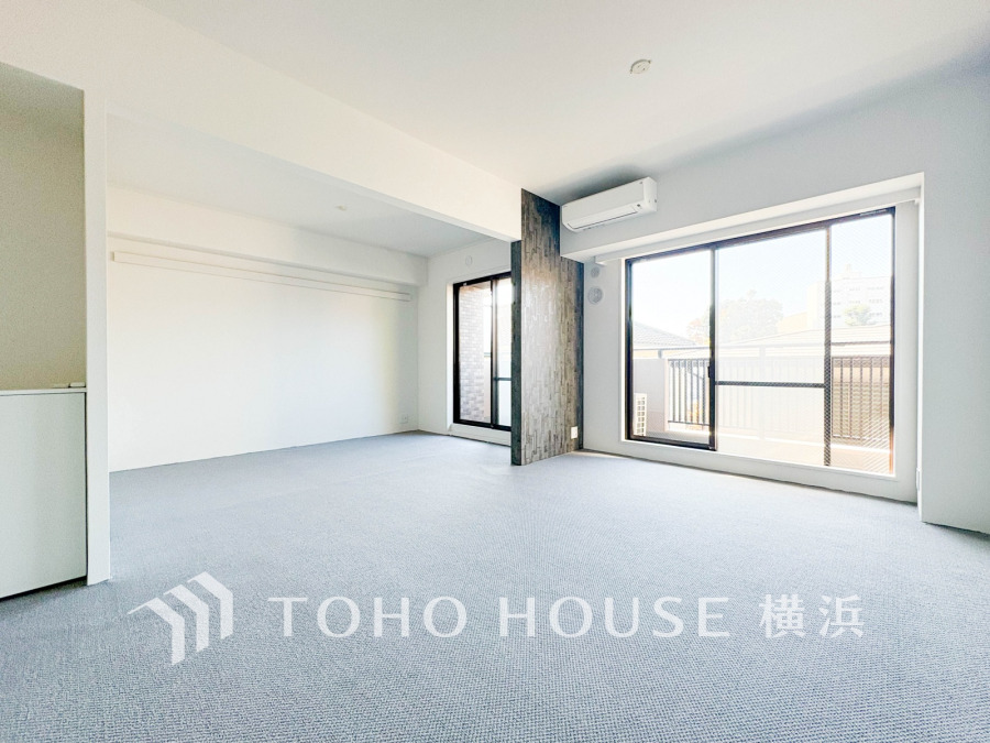 陽当たり良好な広々リビング。大きな窓から自然光が差し込み、快適な住空間を演出します。