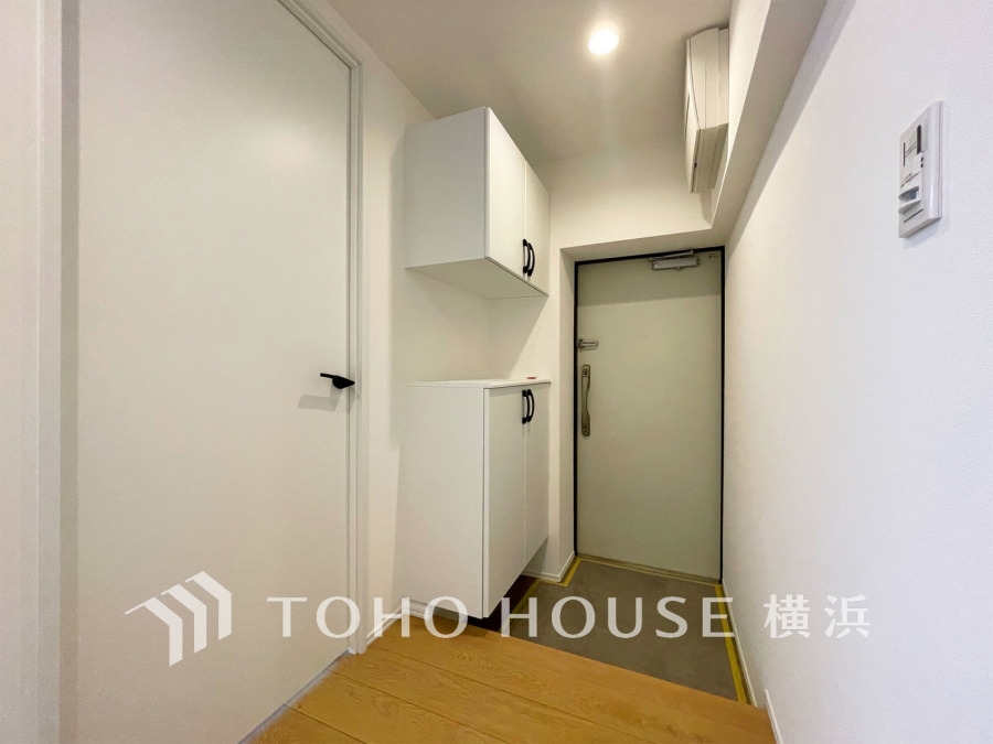 白を基調とした清潔感ある玄関スペース。収納棚付きでスッキリとした空間です。