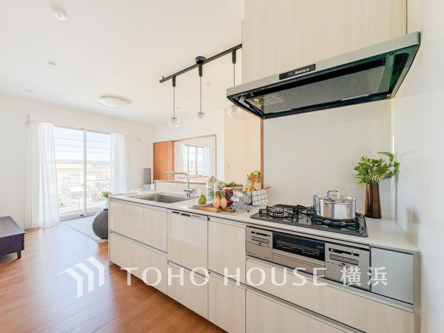 明るい自然光が差し込む、収納充実のシステムキッチン。リビングと繋がる快適な空間設計です。