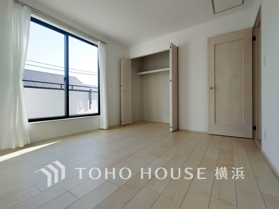 大きな窓から光が差し込む明るい洋室。収納力のあるクローゼット付きで使い勝手も良好です。