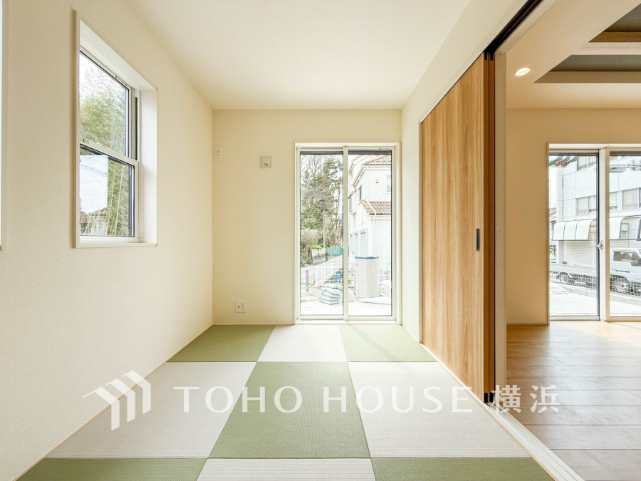 明るい自然光が差し込む、モダンなデザインの和室。使い勝手の良い引き戸でリビングとつながる快適空間です。