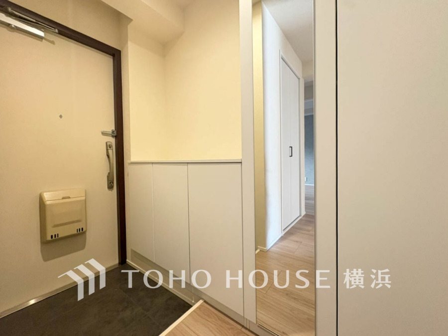 清潔感のある玄関収納付きのシンプルな玄関スペース。大きな鏡で身だしなみもチェック可能です。