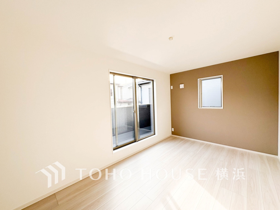 柔らかな陽光が差し込む明るい洋室。アクセントクロスが落ち着いた雰囲気を演出し、快適な住空間を実現しています。