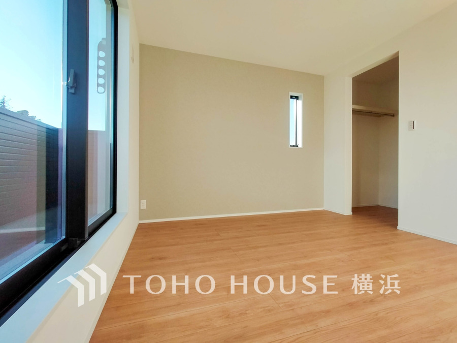 大きな窓から光が差し込む明るい洋室。ウォークインクローゼット付きで収納も充実しています。