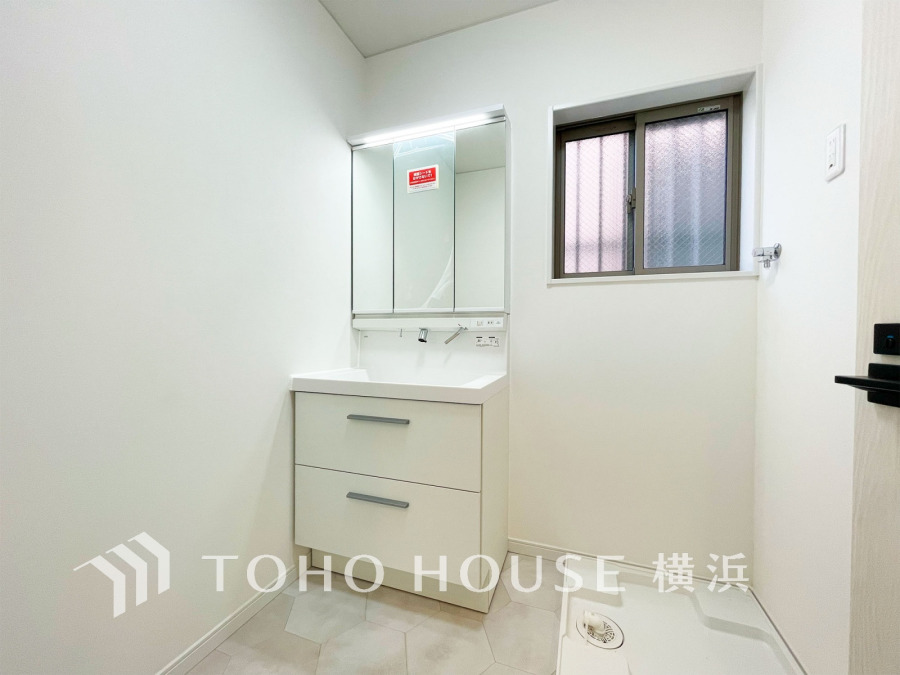 清潔感あふれる白を基調とした洗面室。収納力のある洗面台と換気に便利な小窓付きで快適な空間です。