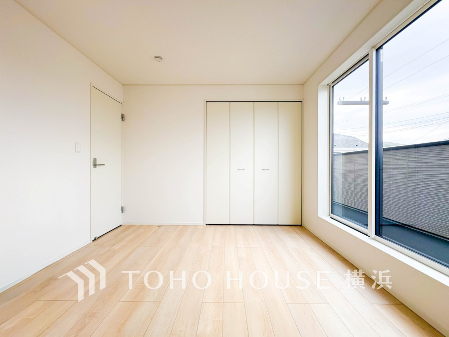 大きな窓から自然光がたっぷり入る明るい洋室。壁一面の収納でスペースを有効活用できます。