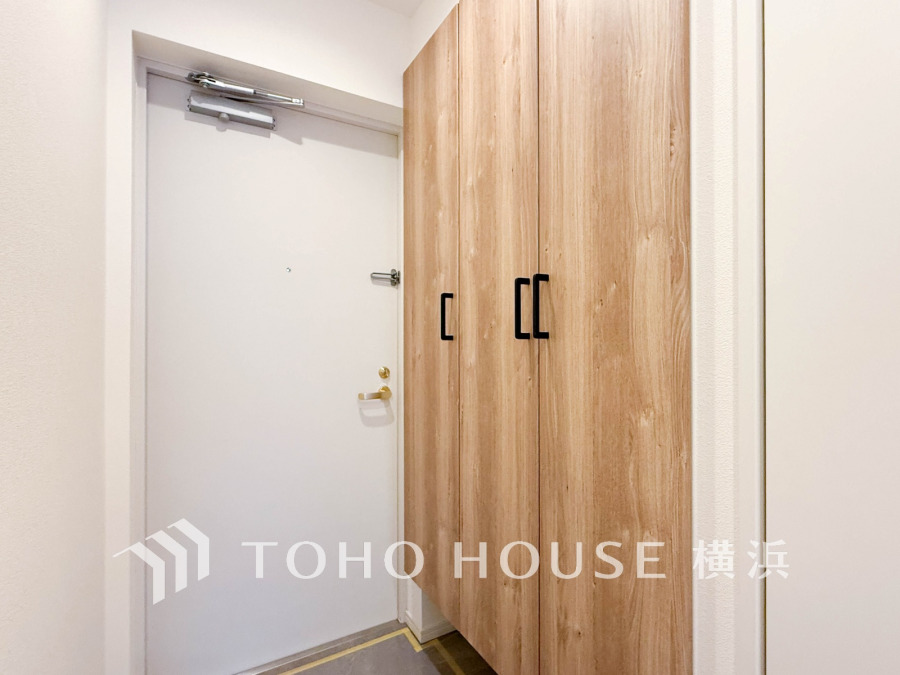 ナチュラルな木目調の収納が並ぶ、清潔感あふれる玄関スペース。すっきりとした印象で使いやすさも抜群です。