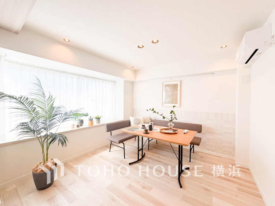 明るい自然光が差し込む、シンプルで落ち着いた雰囲気のリビングダイニング空間です。