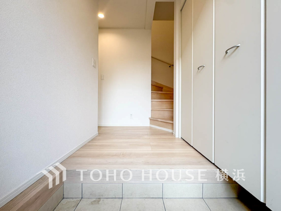 清潔感あふれる玄関ホール。大容量のシューズ収納でスッキリ片付き、明るい木目調の床が温かみを演出します。