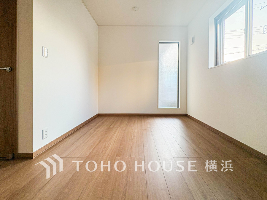 ナチュラルな木目調フローリングと明るい白壁が調和した、落ち着きのあるシンプルな洋室です。