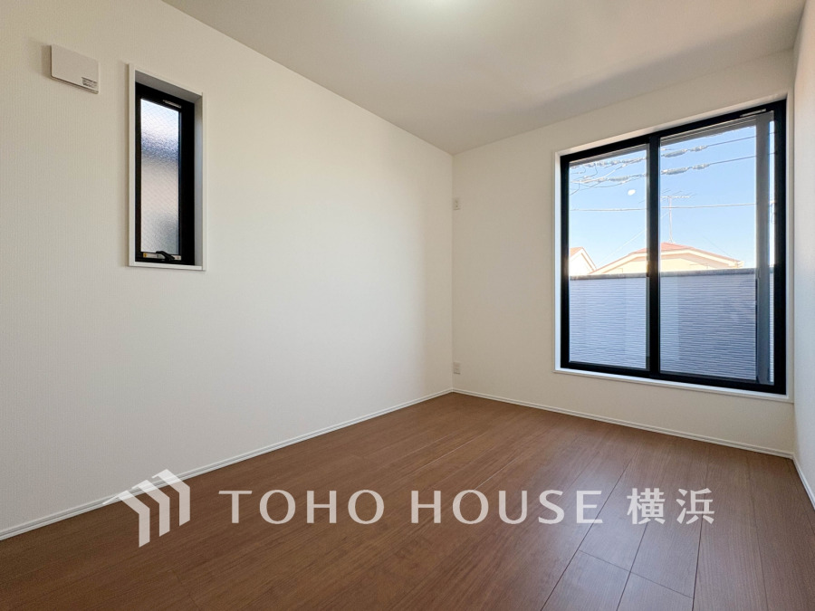 明るい自然光が差し込むシンプルな洋室。落ち着いた木目調フローリングで居心地の良い空間です。