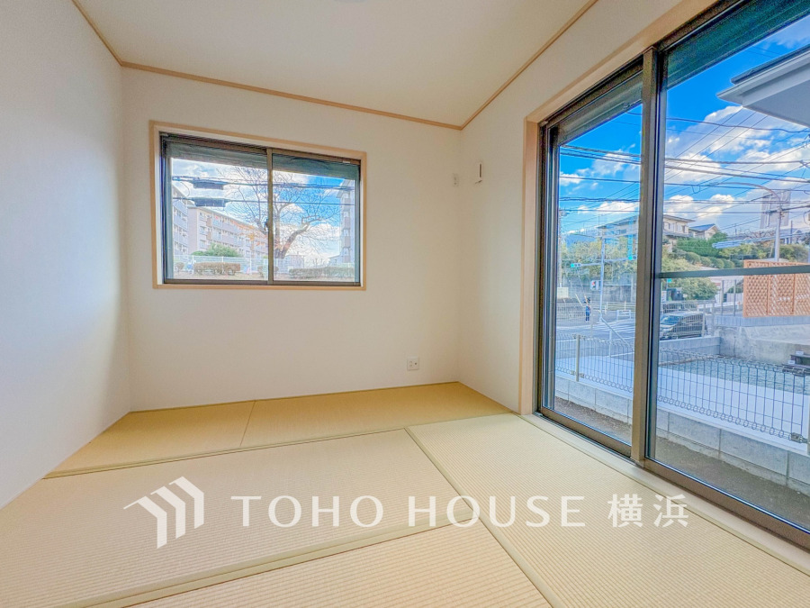 陽光が差し込む明るい和室。大きな窓からは開放的な景色が楽しめ、くつろぎの空間を演出します。