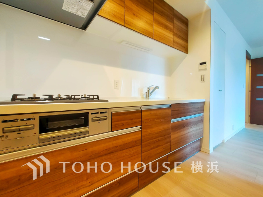 木目調の温かみあるデザインと使いやすい収納が魅力のシステムキッチン。清潔感のある空間で快適な調理が可能です。