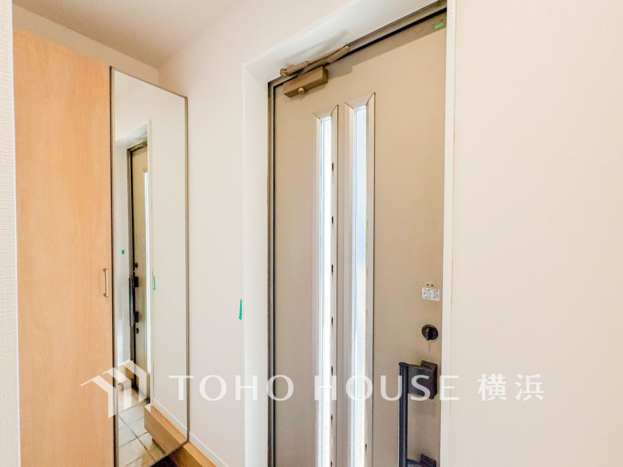 大きな鏡付きの収納で玄関周りもすっきり。明るい光が差し込む快適な玄関スペースです。