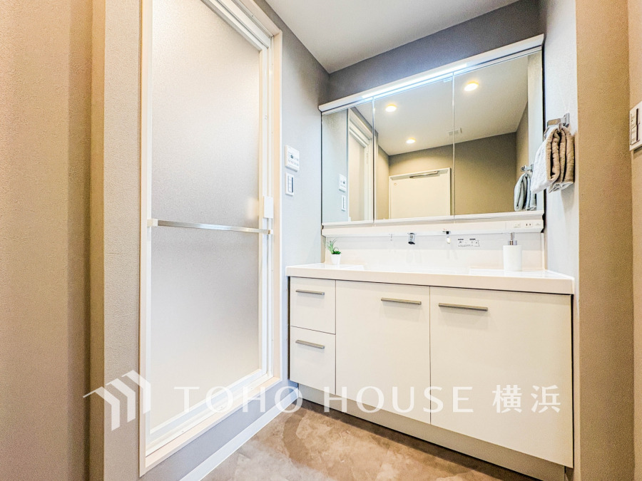 三面鏡裏収納で家族の小物もすっきり片付く洗面台。朝の忙しい時間も、明るい照明と広いカウンターでスムーズな身支度を叶えます。