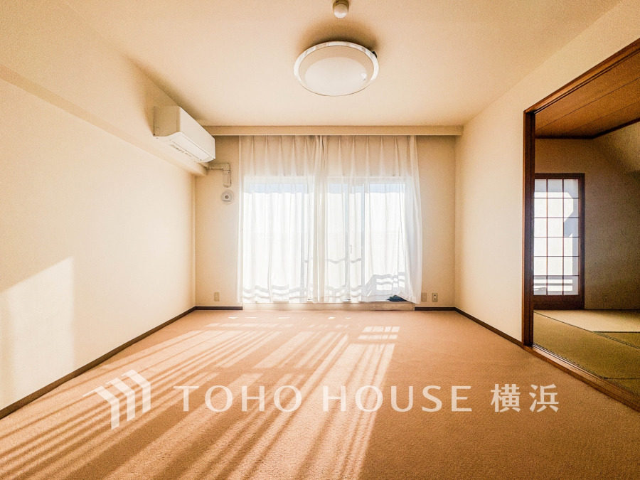 南向きの大きな窓からたっぷり光が差し込む明るいリビング。隣接する和室も魅力の落ち着いた空間です。