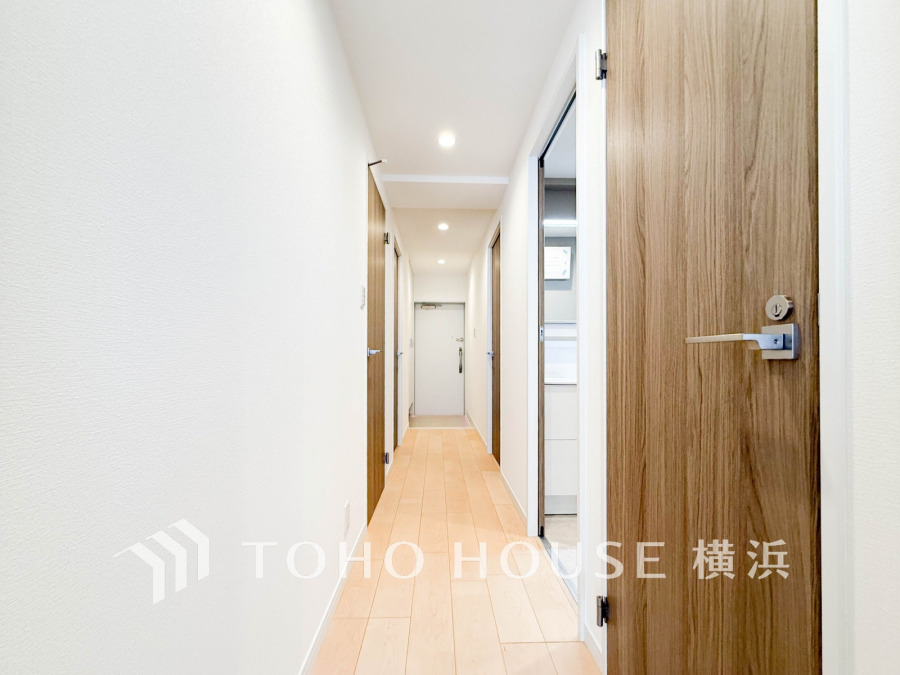 木目調の扉とナチュラルなフローリングで温かみのある空間を演出している廊下スペース。