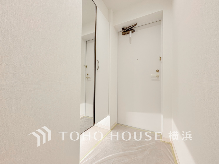 豊富な収納を確保した玄関スペース。便利な大型のミラーのついたシューズボックスを設置。
