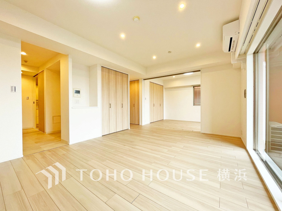 自然光が差し込む広々としたリビングは、木目調のフローリングと白壁で温かみのある空間を演出しています。