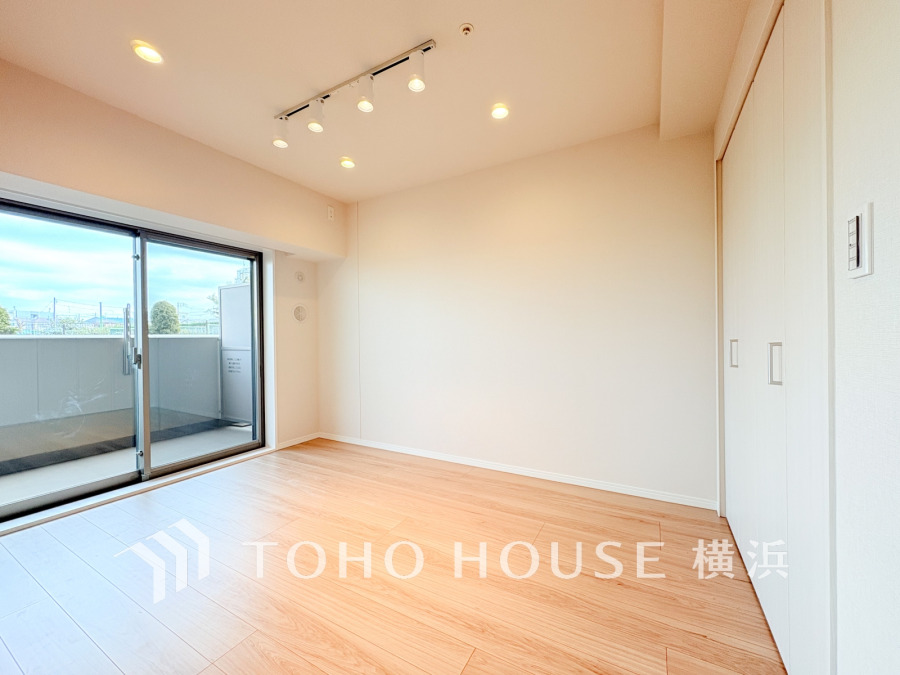 バルコニーから明るい自然光が差し込む洋室。大型クローゼット付きで収納も充実しています。
