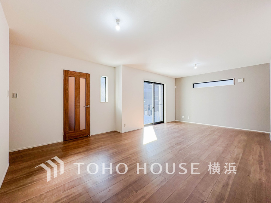 明るい光が差し込む広々としたリビング。木目調のフローリングとシンプルな内装で落ち着く空間です。