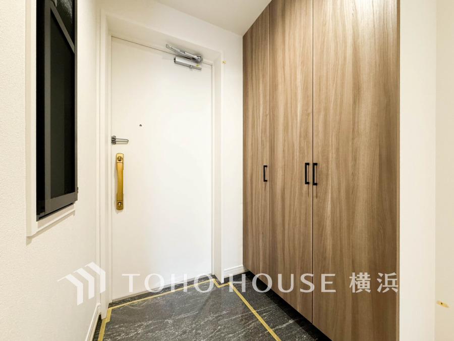 ナチュラルな木目調の収納が映える、清潔感あふれる明るい玄関スペースです。効率的な動線設計が魅力。