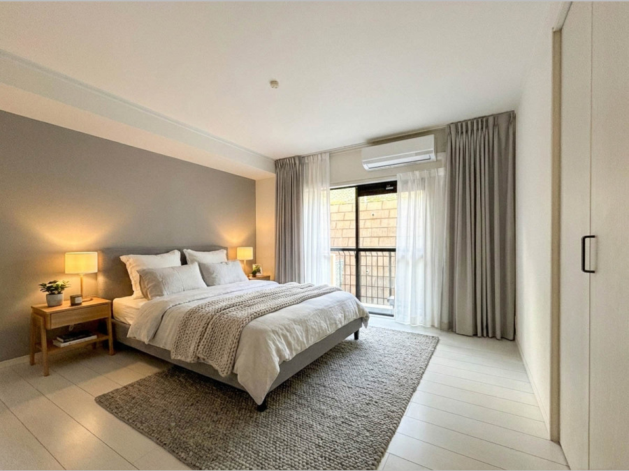 バルコニーに面した明るい洋室。穏やかな陽射しが、ゆったりとした寛ぎの時間を包みます。（家具・装飾品はAI加工です）
