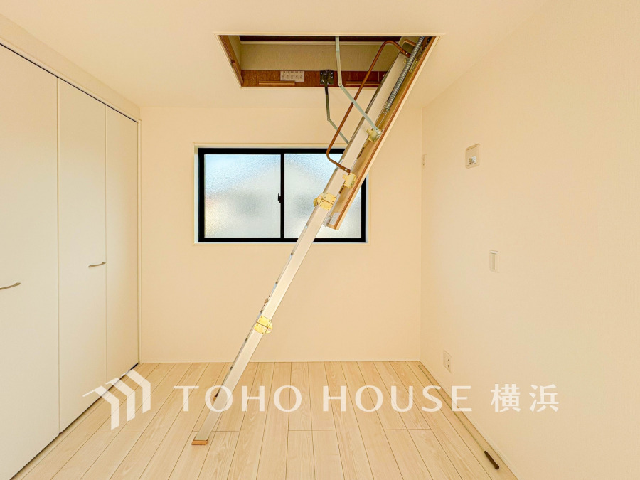 収納力抜群の屋根裏収納付きの明るく清潔感ある洋室。シンプルな設計で多用途に対応可能です。