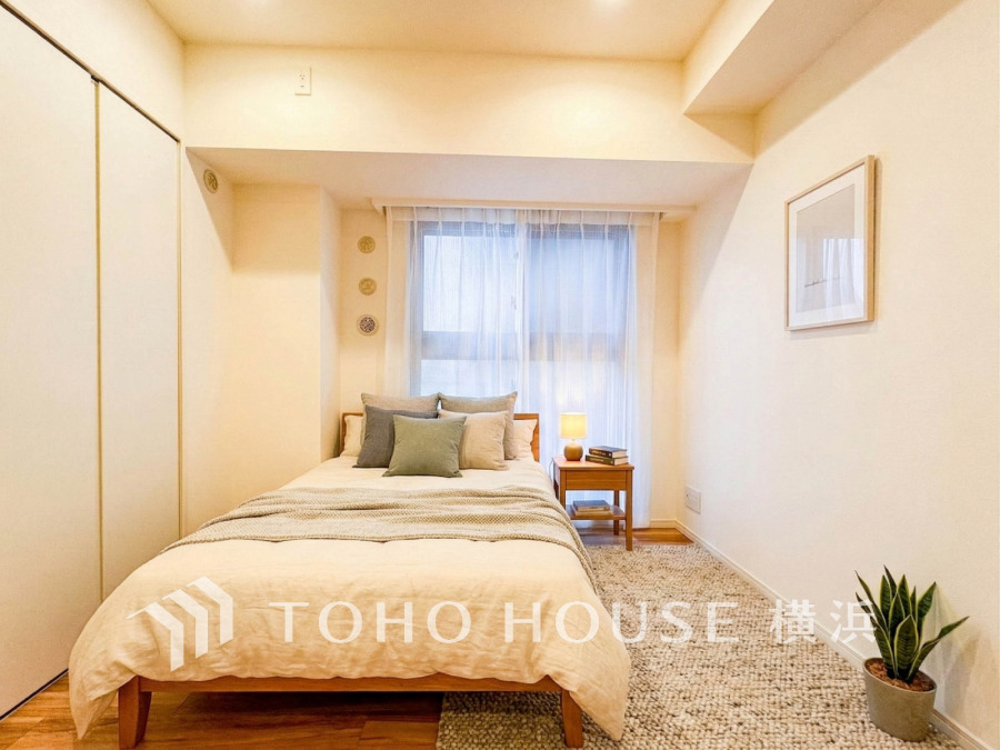 バルコニーに面した明るい洋室。穏やかな陽射しが、ゆったりとした寛ぎの時間を包みます。（家具・装飾品はAI加工です）
