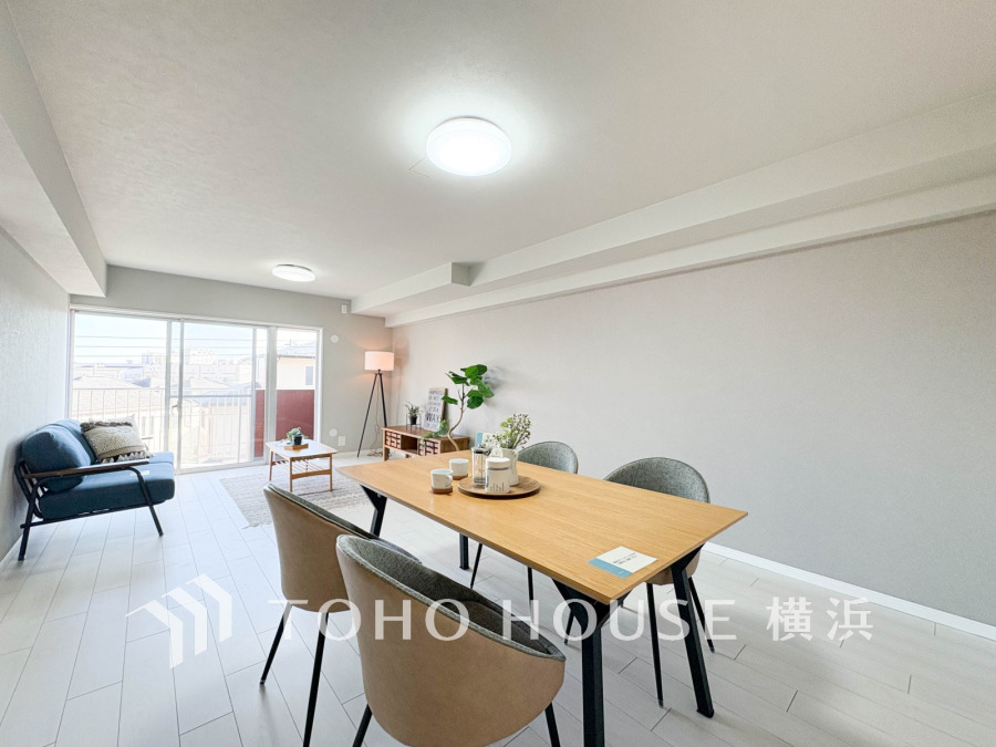 明るい陽光が差し込むシンプルで洗練されたリビングダイニング。くつろぎの空間が広がります。