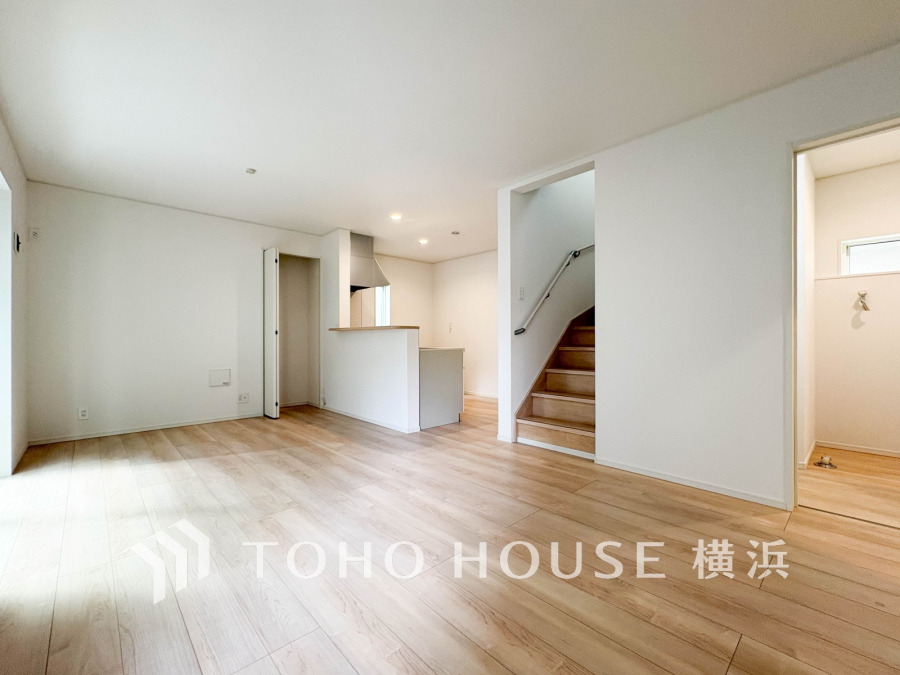 明るい光が差し込む、ナチュラルな木目床の開放的なリビングキッチン空間です。