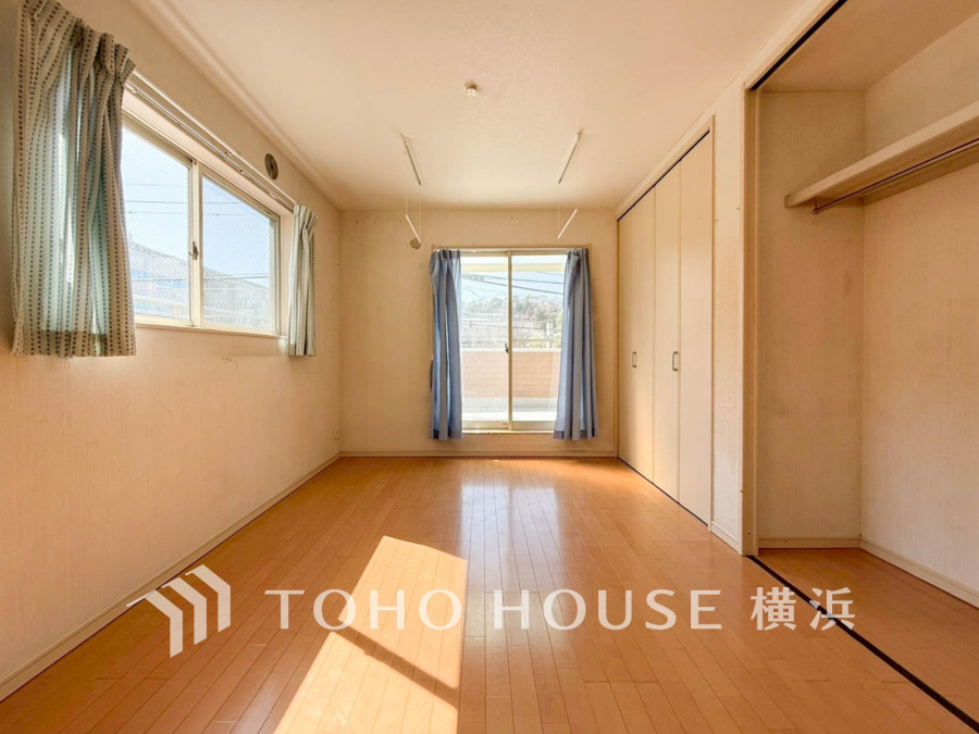 バルコニーから明るい自然光が差し込む洋室。大型クローゼット付きで収納も充実しています。
