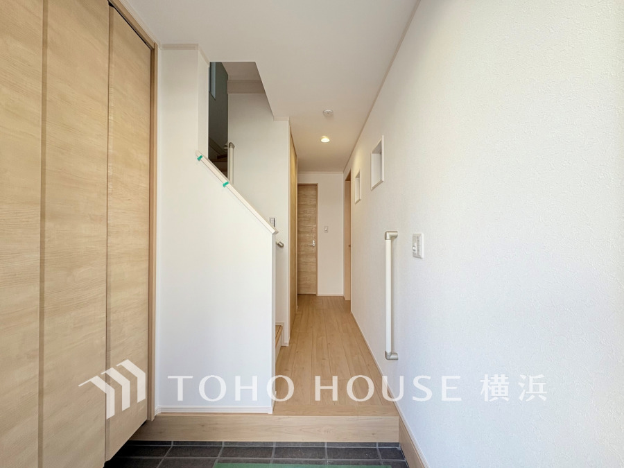 明るく清潔感のある玄関ホール。大容量の収納と手すり付きで安心・快適な住まいを実現します。