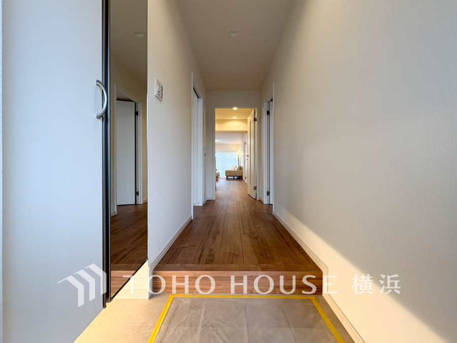 明るく開放的な玄関ホール。木目調のフローリングが温かみを演出し、室内へと自然に誘います。