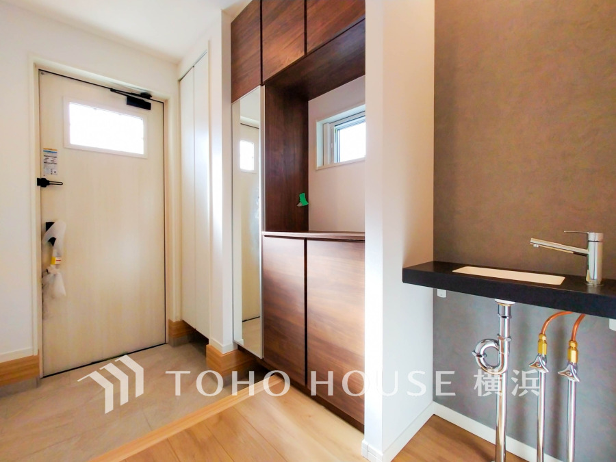 収納豊富でゆとりある玄関スペース。衛生面に配慮した手洗いカウンターも設置しました。