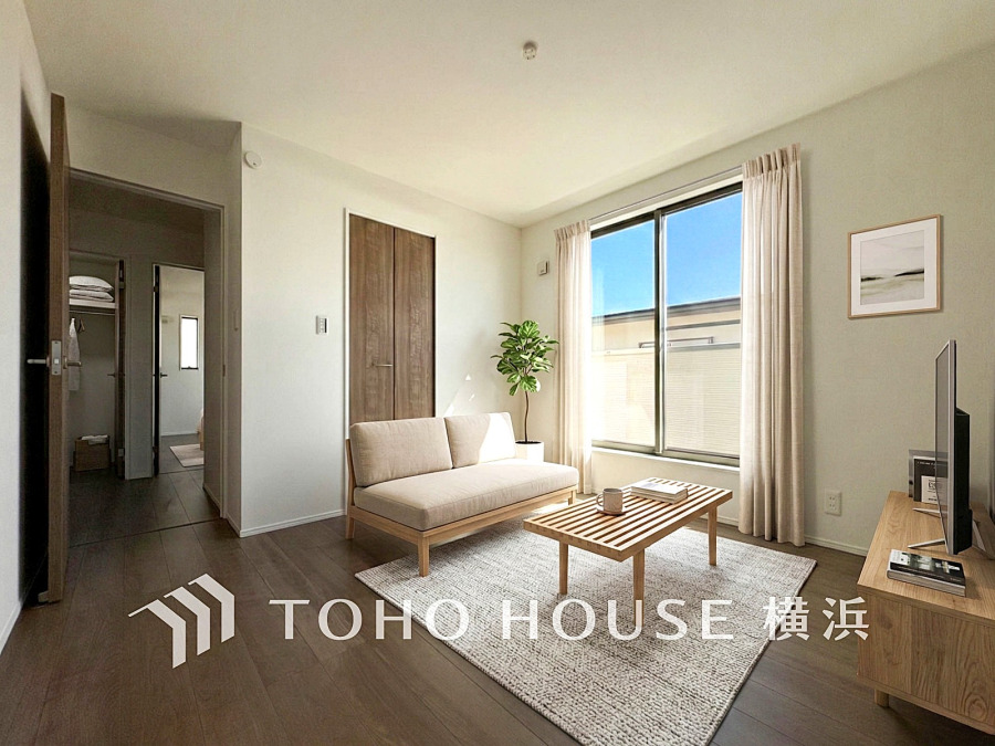 明るい陽射しが差し込むリビングは、シンプルで落ち着いたナチュラルテイストの空間です。（装飾品はAIイメージです）