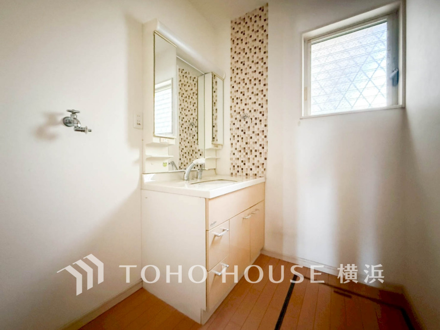 窓から自然光が差し込む明るい洗面スペース。収納も充実した使いやすい設計です。