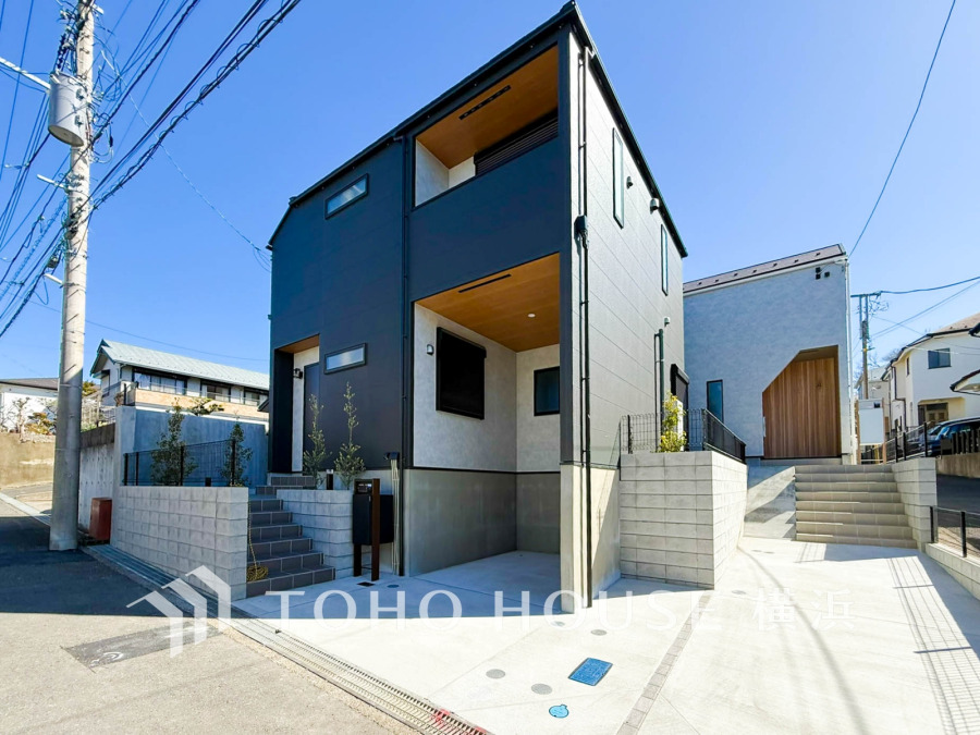 スタイリッシュな黒の外壁が目を引く、充実した駐車スペース付きのモダン住宅です。